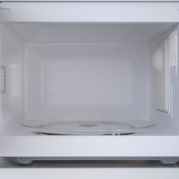Empty microwave interior with glass turntable, ready for use.