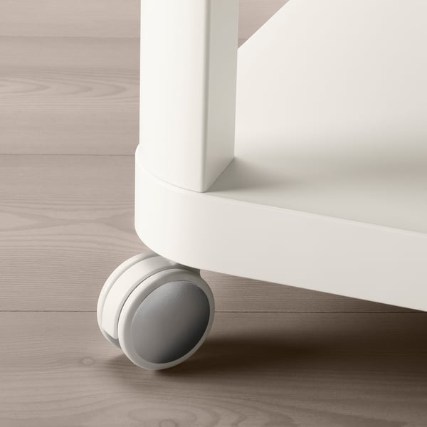 Close-up of white table leg with smooth, large wheel castor on light wooden floor.