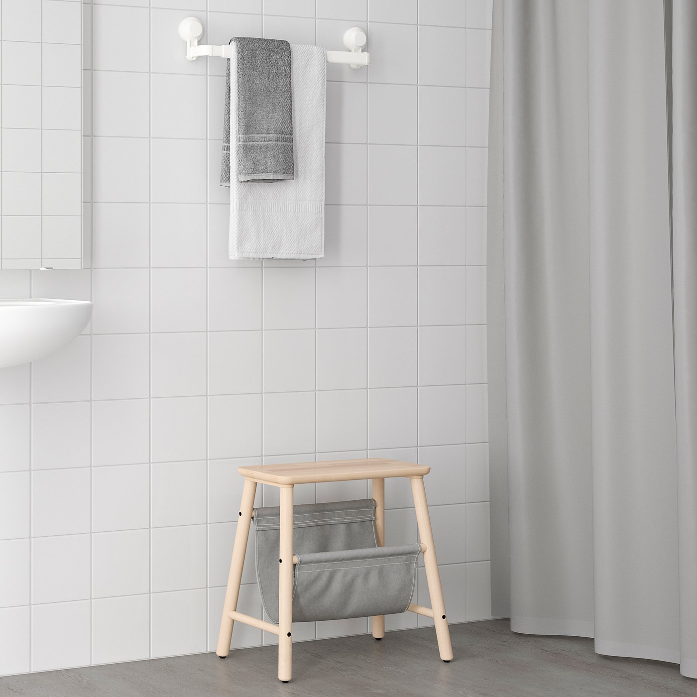 Wooden bath stool with grey TISKEN bag, perfect for bathroom storage.