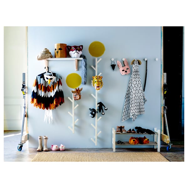Kids entry area with TJUSIG coat rack, yellow and white, wooden. Masks, boots, and toys.