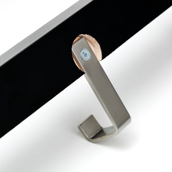 A stainless steel hook attached to a wooden and metal stand, showing quality craftsmanship and sturdy construction.