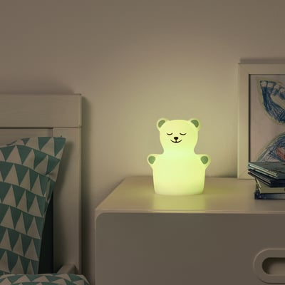 Cosy bedside table with TÖVÄDER bear nightlight and pillow.