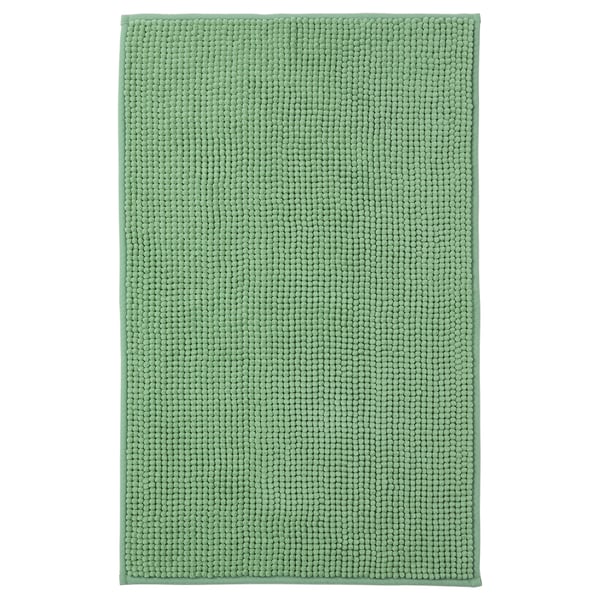 A green TOFTBO bath mat. Its rectangular, soft, and made from recycled polyester with a textured surface.