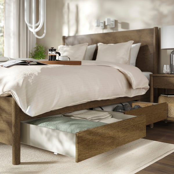 Bed with drawer and bedside table items.