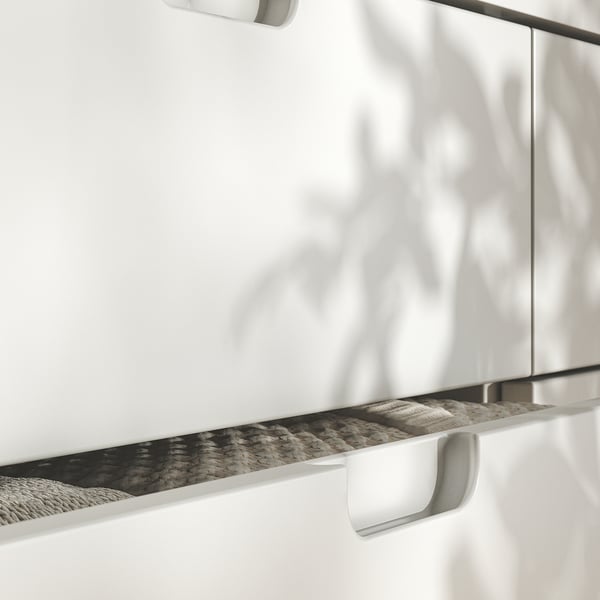 Modern white cabinet with sleek handles and textured shadow effect.