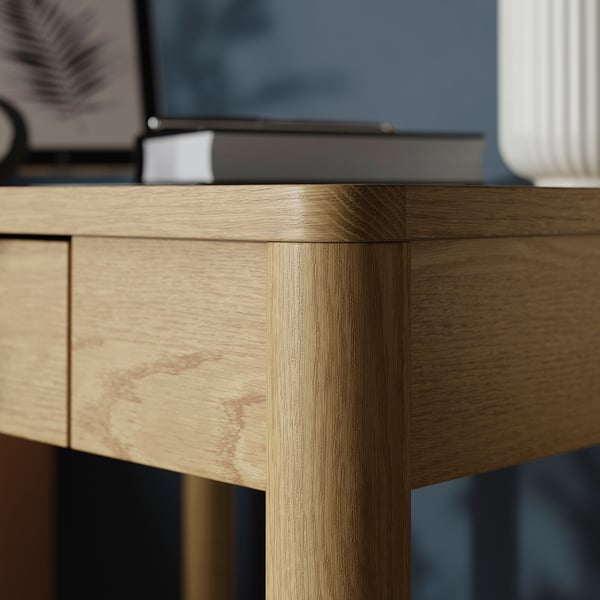 Close-up of TONSTAD desks fine-grained oak veneer, showcasing its smooth, durable finish and precise joinery.