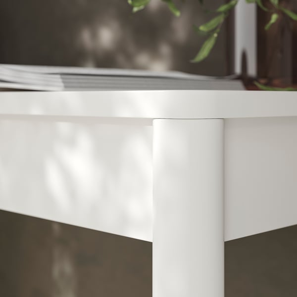 Close-up of modern, glossy white desk corner with smooth finish, showing clean lines and sturdy design.