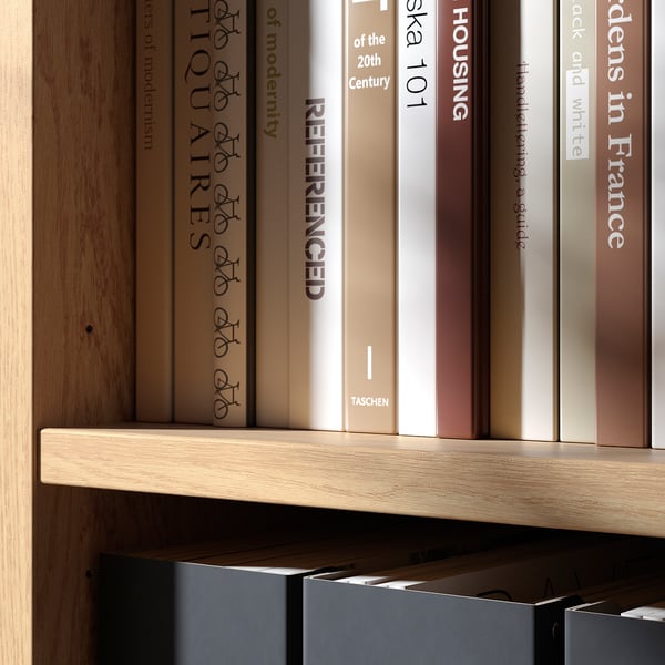 Books organised neatly on wooden shelves. Shelves made of light, smooth-finished wood with adjustable compartments.