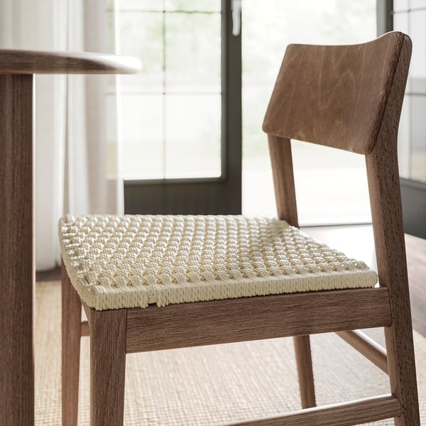 Close-up of a wooden chair with woven seat, showcasing fine craftsmanship and natural wood finish.