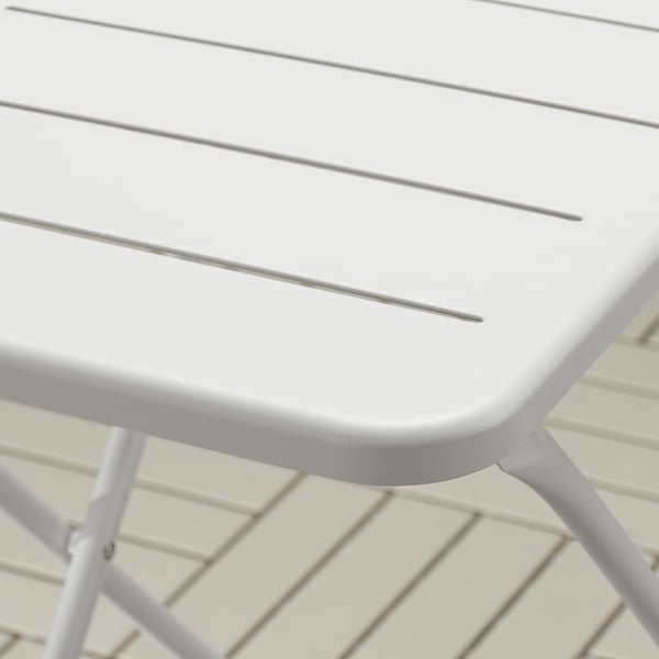 Close-up of TORPARÖ table. Smooth, powder-coated steel surface with drainage channels. Sturdy, weather-resistant design.