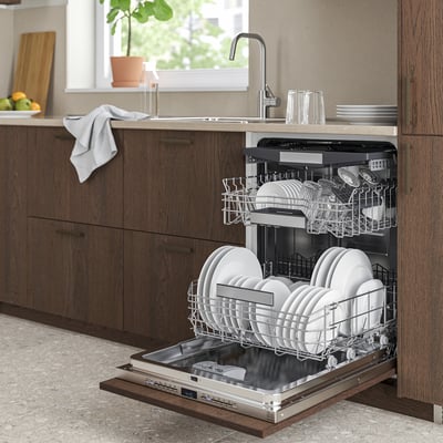 A modern kitchen with dark wooden TORSBODA dishwasher, filled with dishes, open beside brown cabinets.