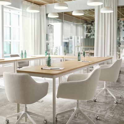 Modern minimalist office with light-wood tables, TOSSBERG chairs, large windows, and white pendant lights.