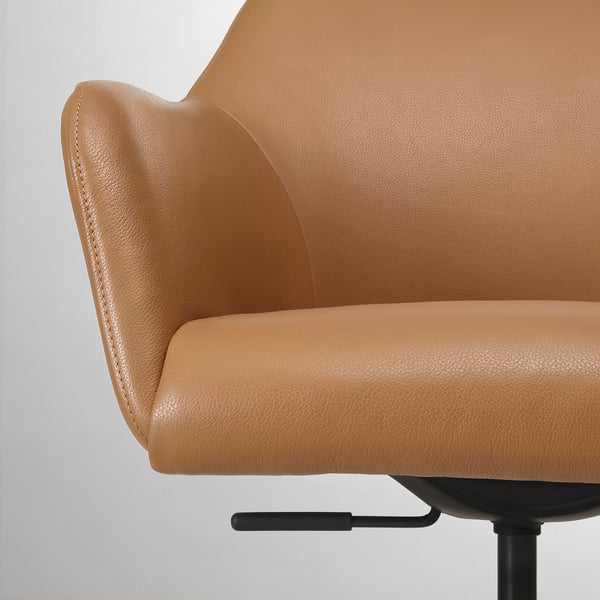 Close-up of a sleek, well-crafted tan leather office chair with smooth edges and detailed stitching.
