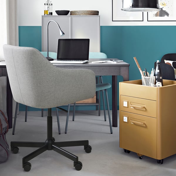 Modern home office with TOSSBERG chair, laptop, lamp & filing cabinet.