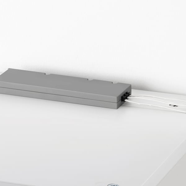 Grey TRÅDFRI led driver on white surface, controls 10 lights wirelessly.