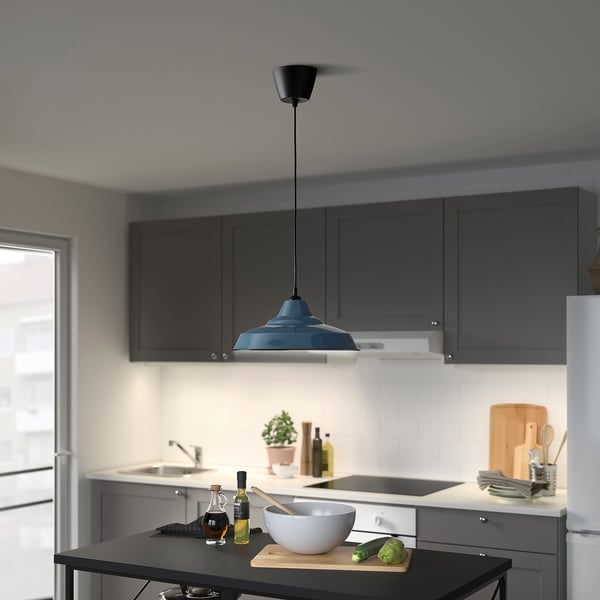 Modern kitchen with TRETTIOEN lamp illuminating counter workspace.