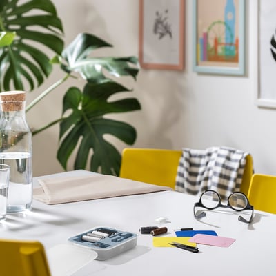 TRIXIG mending kit on white table with plant and chairs.