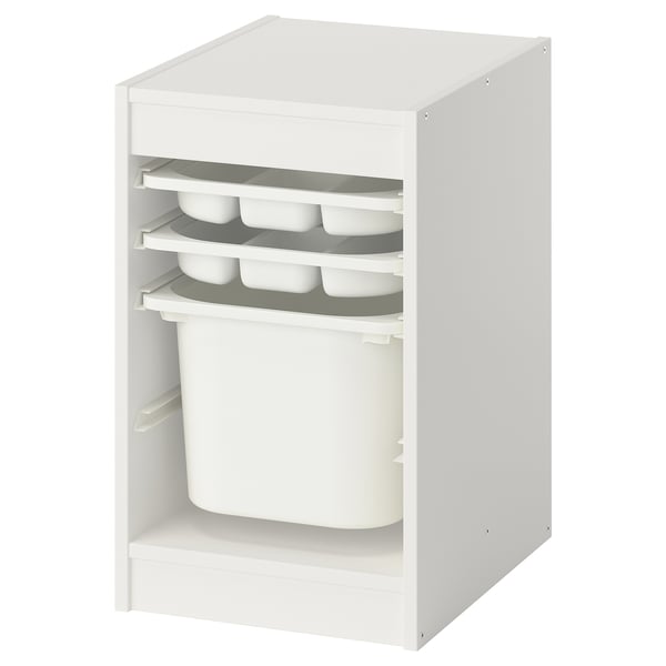 A white TROFAST storage unit with plastic drawers and a bin. Its designed for organizing kids items.