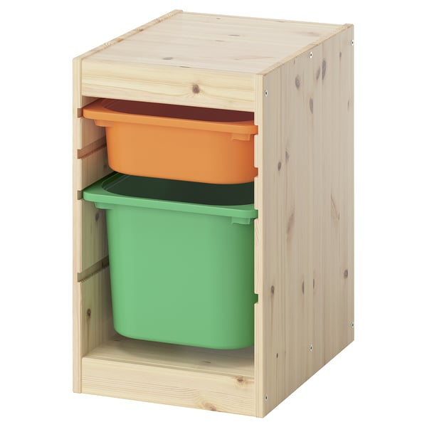 An ikea TROFAST storage unit with bright orange and green plastic bins inside a light wooden frame.