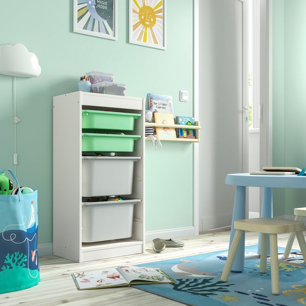 Kids room with white TROFAST drawers, wall shelf, blue table, and decor.