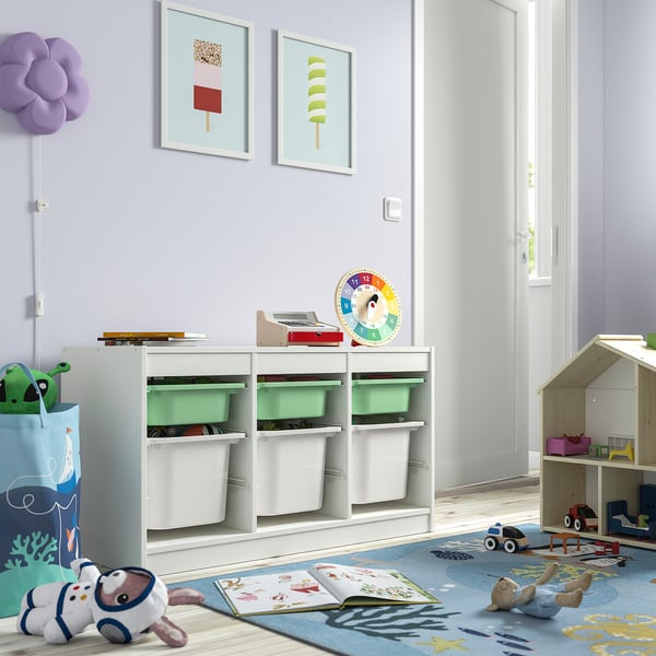 Childs playroom with TROFAST white storage units. Sized to fit neatly, holding colourful bins and toys. Bright, playful, and organised.