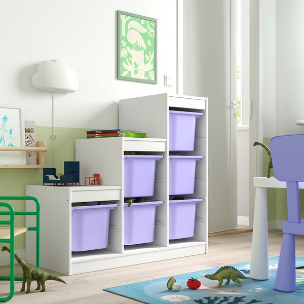 White TROFAST storage with purple bins for kids toys, green dinosaurs, and colourful rug in corner.
