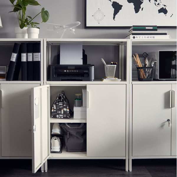 White TROTTEN storage unit, metal-made with adjustable feet, fitting common office items, featuring lockable doors for privacy.