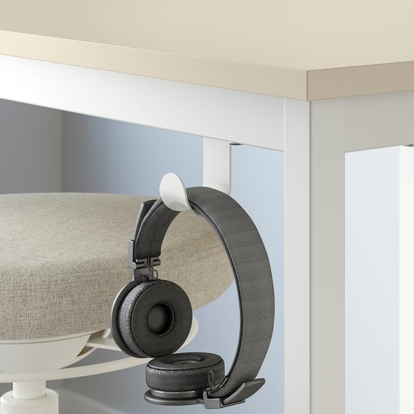 Modern beige meeting table with wall-mounted headphone hook for flexible, spontaneous meetings.