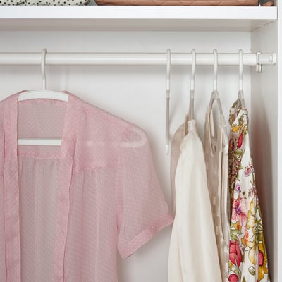 Closet with light pink garments on white anti-slip hangers.