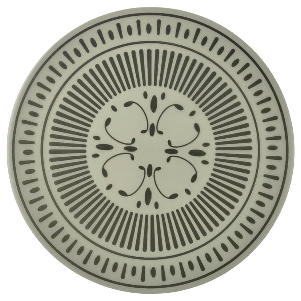A round, light-colored plastic place mat with intricate black patterns.