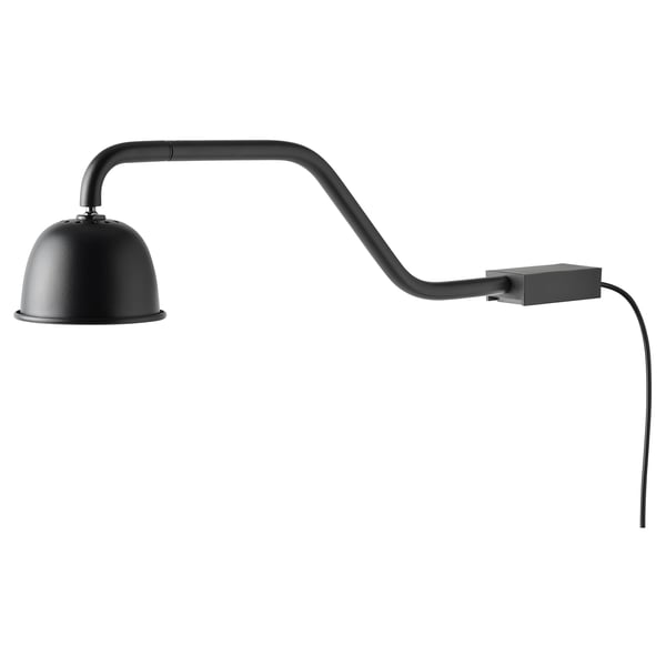 A black TVÄRDRAG wall lamp with a movable arm and domed shade, designed for focused lighting.