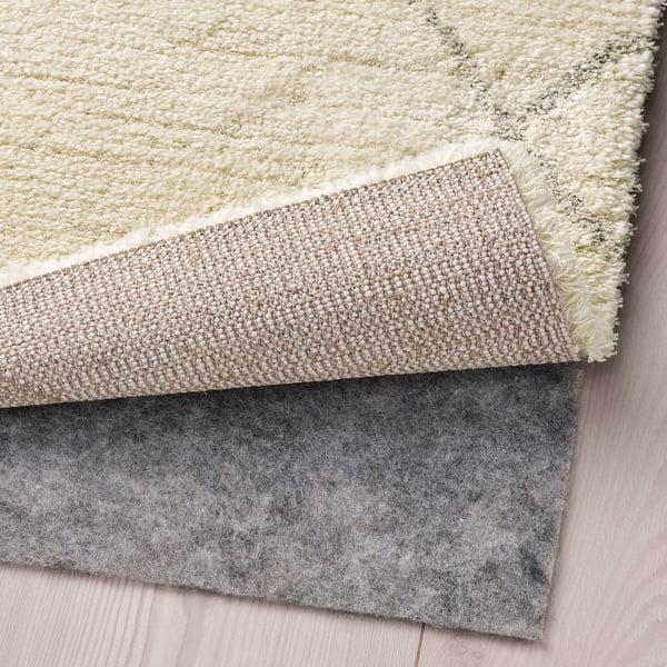 Three layered rugs: soft cream on top, textured beige in the middle, and dark grey felt underneath for grip, enhancing comfort and safety.