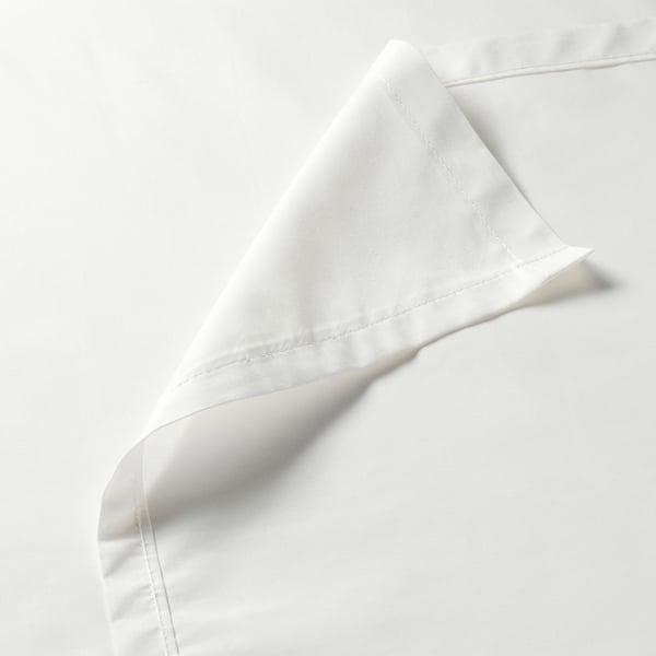 Close-up of crisp, white bed sheet showcasing high-quality stitching and smooth fabric texture.
