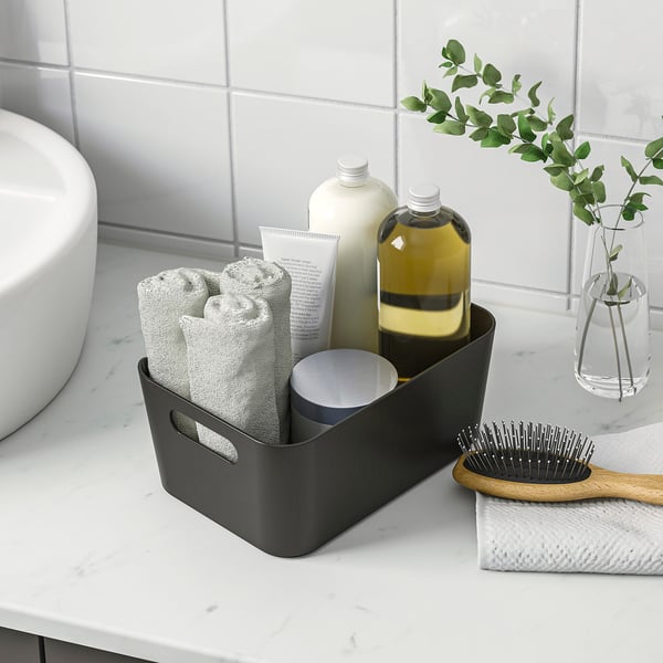 Dark box stores towels, bottles, and brush neatly, with handles for easy carrying.