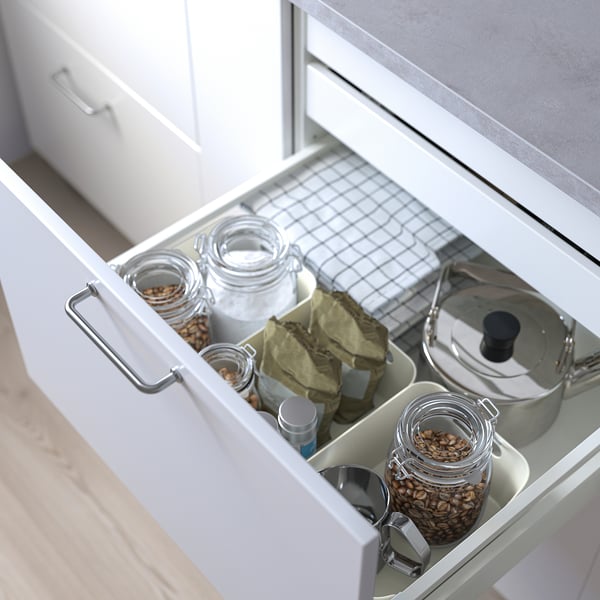Open kitchen drawer with jars, bags, and lids, organised for easy access.