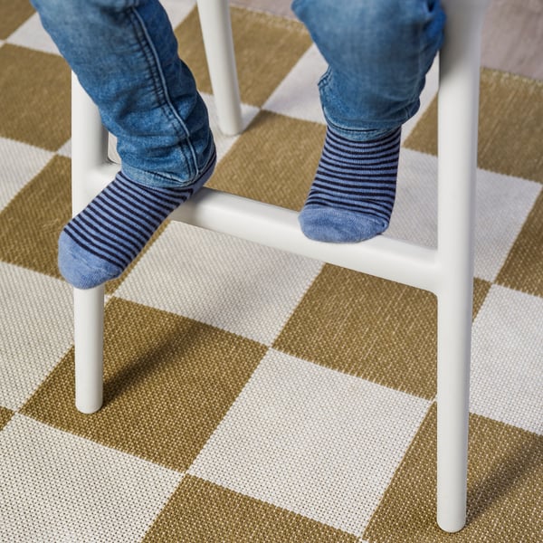 Childs feet in striped socks on a white junior chair, perfect for dining table height.