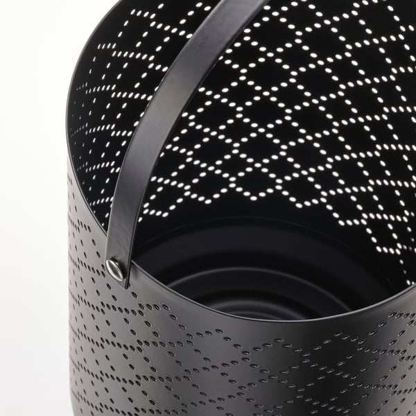 Black perforated metal lantern with curved handle. Hole pattern allows light to shine through, creating a decorative glow.