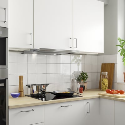 Modern kitchen with white UTDRAG hood above wooden countertop, cookware, and plant.