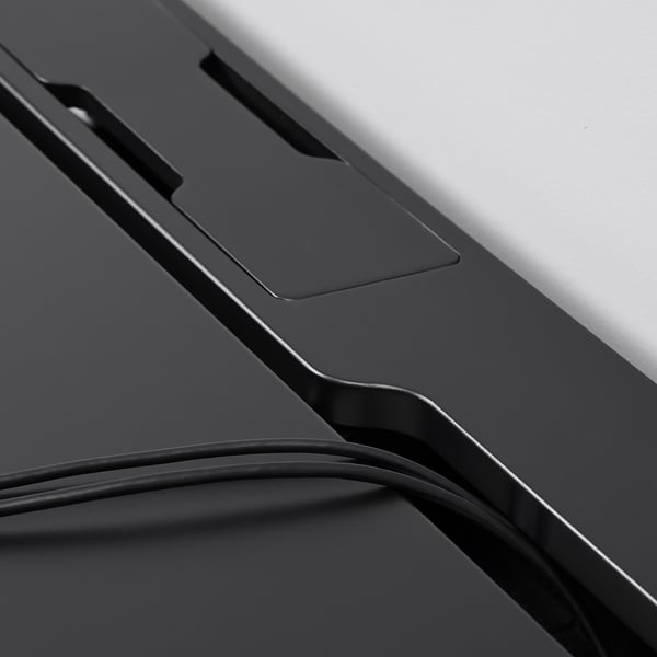 Close-up of durable, matte desk surface, showing sleek design and cable management slot, emphasising quality and functionality.