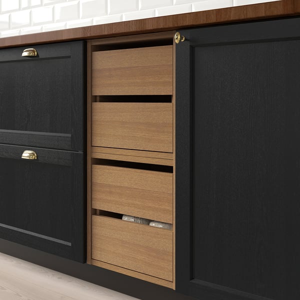 Black kitchen cabinets with three wooden pull-out drawers, each with built-in compartments, designed for organised storage.