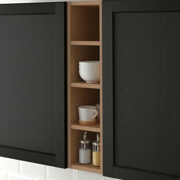 Dark wooden kitchen cabinet with open section displaying white bowls, cups, and jars, showcasing storage and organisation.