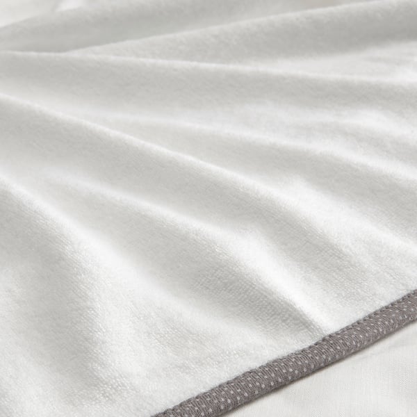 Close-up of soft, white, terry cloth baby changing mat cover, showcasing smooth fabric and sturdy hemmed edge.