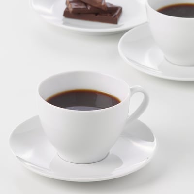 Two white porcelain cups of coffee on saucers, durable and designed for both daily and formal use.