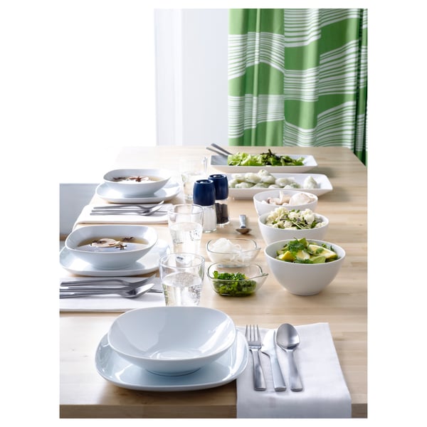 White dishes, green curtains, cutlery, napkins on table