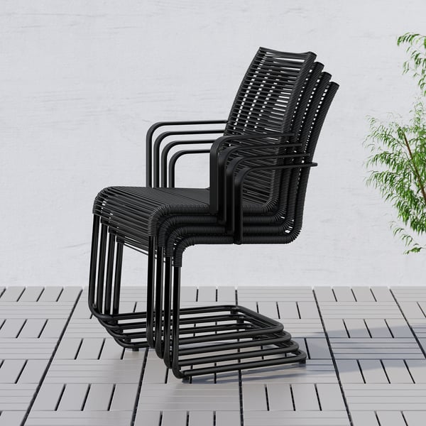 Three black outdoor chairs, modern, stacked with support armrests & high backs.