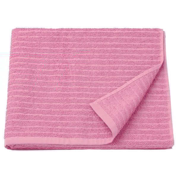 A folded bright pink VÅGSJÖN towel made of 100% cotton, featuring a textured design.
