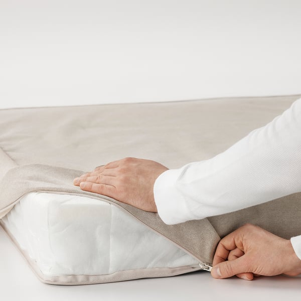 Hands zipping mattress cover, showing easy cleaning feature.
