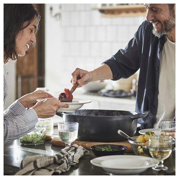 Couple cooking with VARDAGEN pan, smiling.