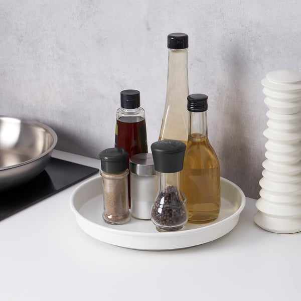 A kitchen turntable holding bottles, jars, and a bowl. The turntable rotates 360°, providing easy access to all items.