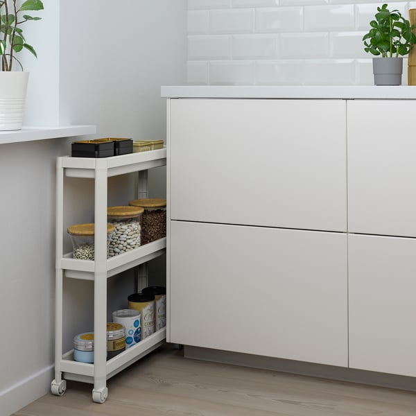 VESKEN white bathroom trolley, three shelves stocked with toiletries. Slim, fits in tight spaces. Made of recycled plastic.